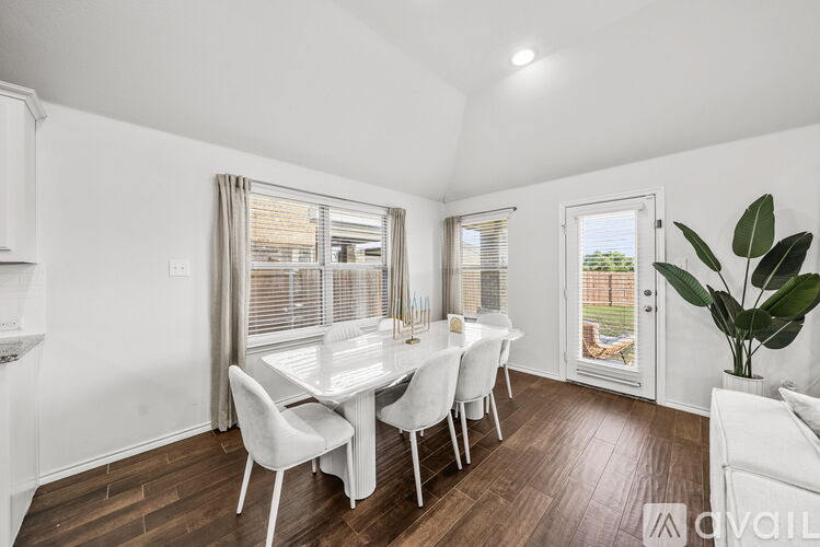 A dining room with a table and chairs.