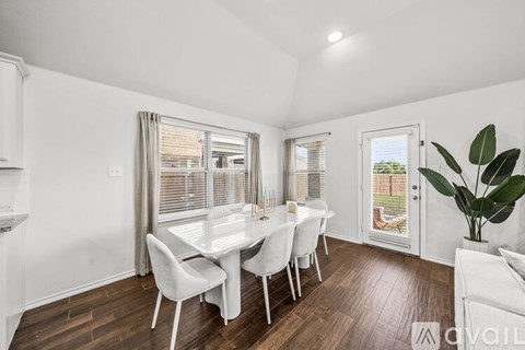 A dining room with a table and chairs.