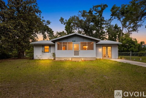 A house with a front yard and a fence is available for sale.