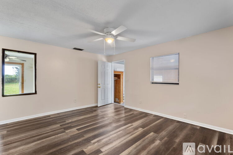 A room with wooden flooring and a ceiling fan.