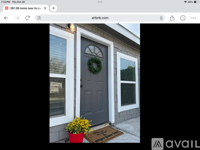 A house with a dark grey door and a wreath on it.