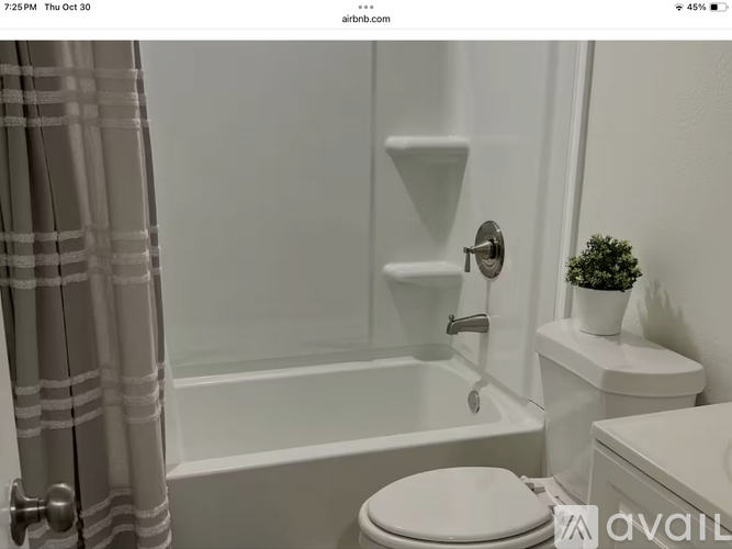 A white toilet sits next to a bathtub in a bathroom.