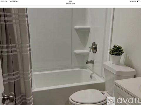 A white toilet sits next to a bathtub in a bathroom.