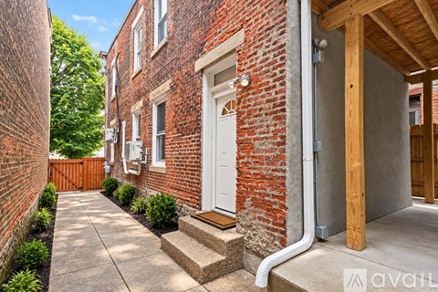 A red brick house with a white door and a wooden porch.