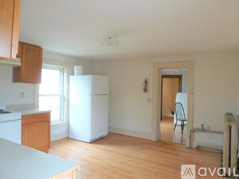 A kitchen with white appliances and wooden cabinets.
