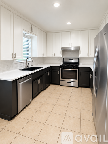 A kitchen with black cabinets and appliances.