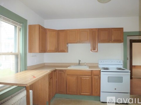 A kitchen with wooden cabinets and a white stove.