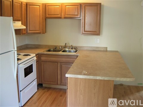 A kitchen with wooden cabinets and a white refrigerator.