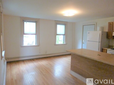 A kitchen with a white refrigerator and wooden floors.