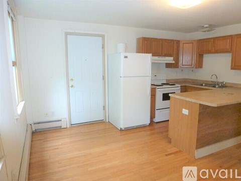 A kitchen with wooden floors and white appliances.