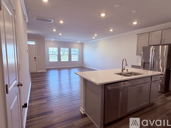 A kitchen with a white countertop and wooden flooring.