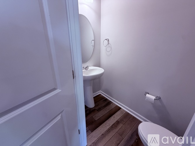 A white toilet sits in a bathroom next to a white door.