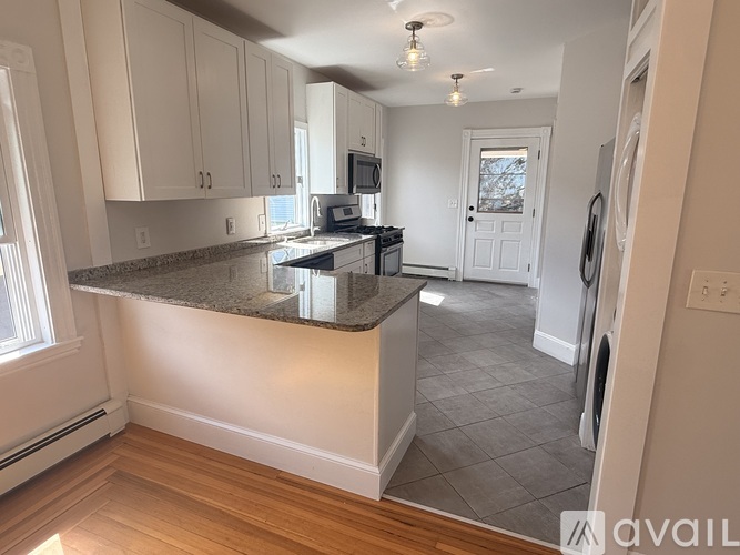 A kitchen with a granite countertop and wooden flooring.