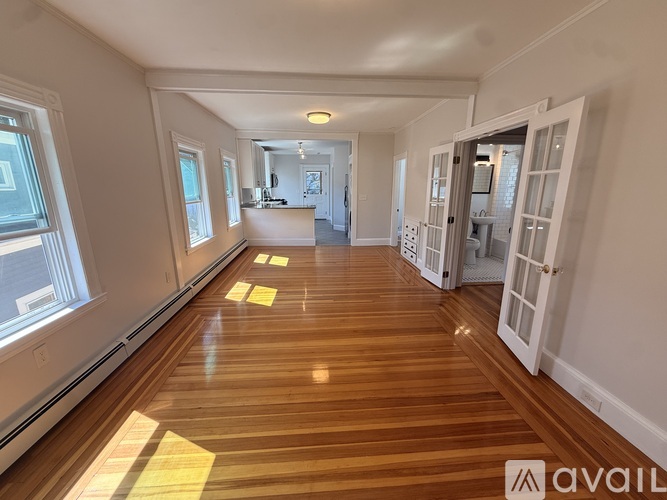 A long hallway with wooden floors and white walls.