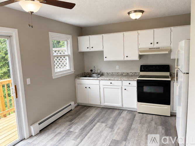 A kitchen with white cabinets and appliances.