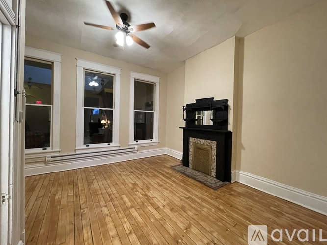A room with a fireplace and a ceiling fan.