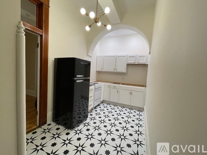 A black and white kitchen with a black fridge.