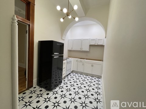 A black and white kitchen with a black fridge.