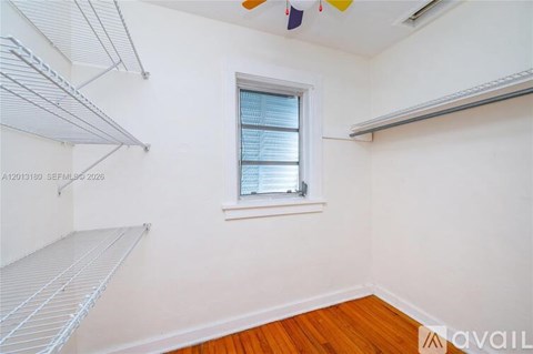 A room with a window and a shelf.