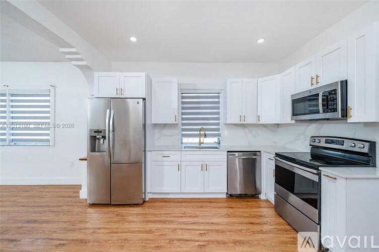 A kitchen with white cabinets and stainless steel appliances.