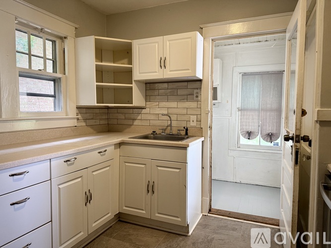 A kitchen with white cabinets and a window above the sink.
