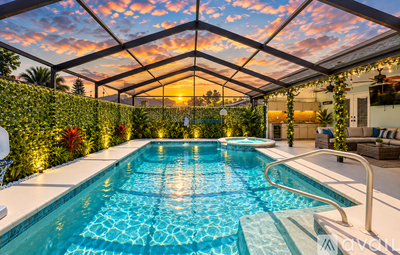 A swimming pool inside a house with a sunset in the background.