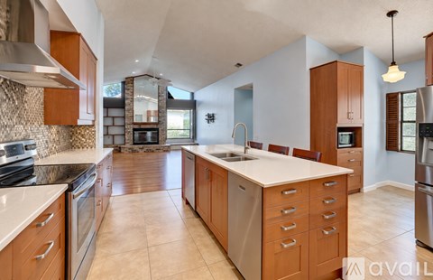 A kitchen with wooden cabinets and a large island.