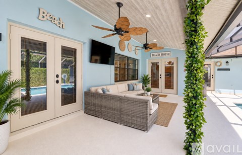 A living room with a couch and a ceiling fan.