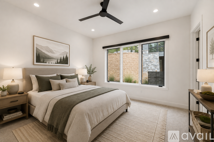 A bedroom with a large bed and a ceiling fan.