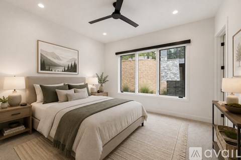 A bedroom with a large bed and a ceiling fan.