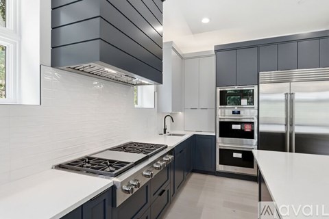 A modern kitchen with a stove top oven and a refrigerator.