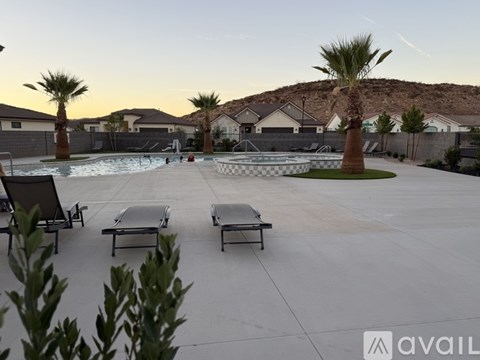 A pool area with lounge chairs and palm trees.