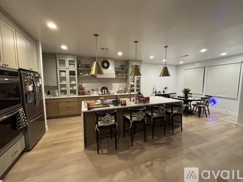 A modern kitchen with a large island and dining area.