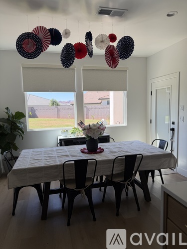 A dining room with a white table and chairs.
