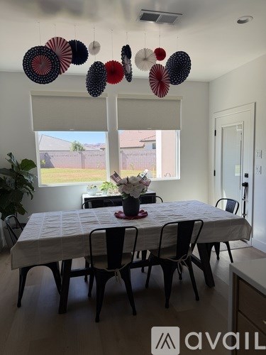 A dining room with a white table and chairs.