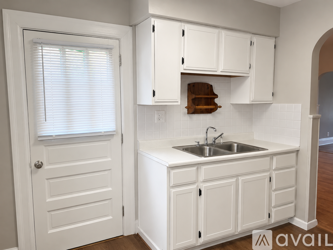 A kitchen with white cabinets and a white sink.