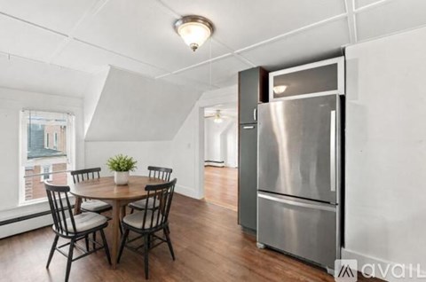 A kitchen with a table and chairs in front of a window.