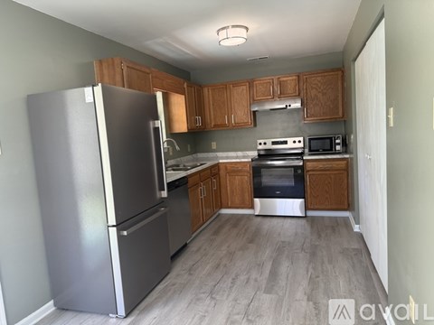 A kitchen with a refrigerator, oven, and microwave.