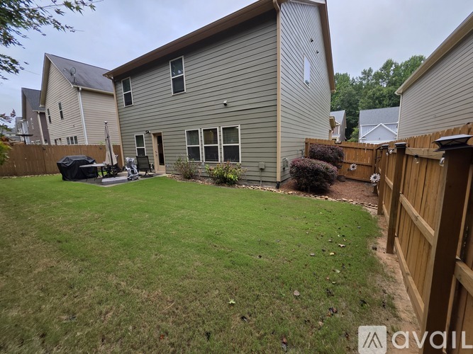 A backyard with a lawn and a house.