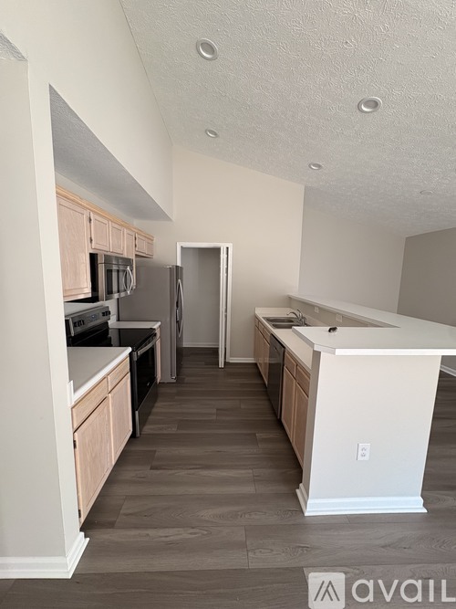 A kitchen with wooden floors and white walls.