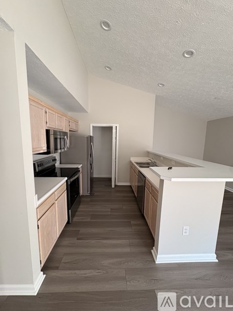 A kitchen with wooden floors and white walls.