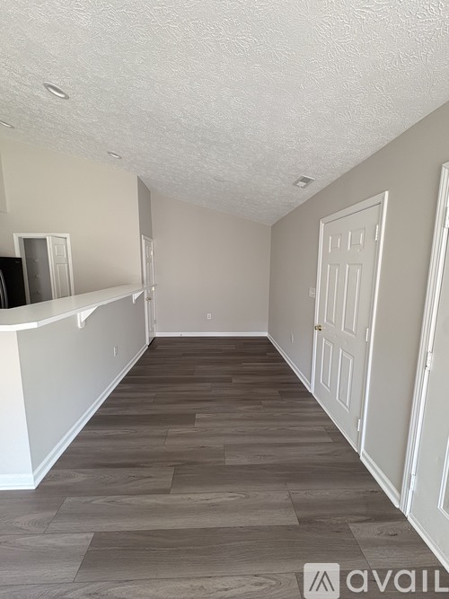 A room with a white door and a white counter top.