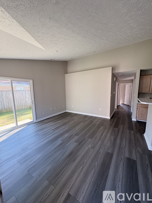 A room with wooden flooring and a sliding glass door.