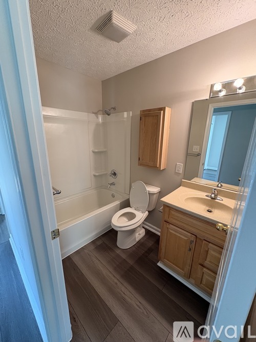 A bathroom with a toilet, sink, and bathtub.