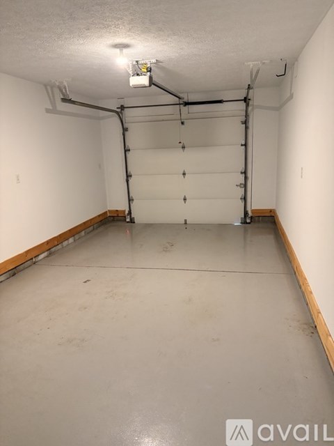 A spacious empty room with a white ceiling and walls, and a wooden floor.