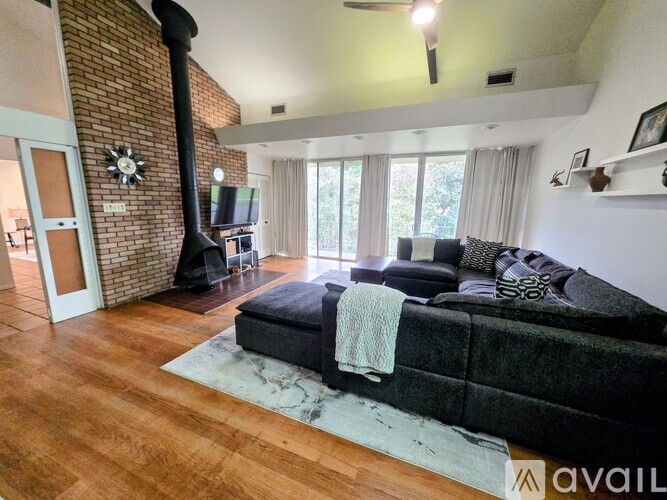 A living room with a black couch and a fireplace.