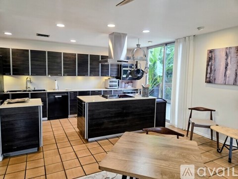 A modern kitchen with black cabinets and a wooden island.