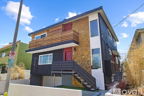 A modern two-story house with a combination of black, white, and wood exterior.