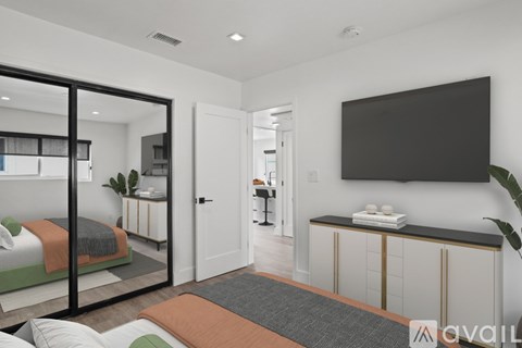 A modern bedroom with a large bed and a flat screen TV mounted on the wall.