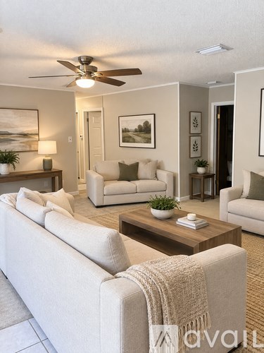 A living room with a white couch and a wooden coffee table.